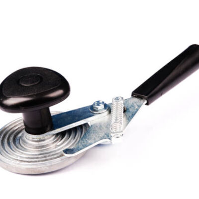 Machine for rolling metal caps on glass jar on white background.